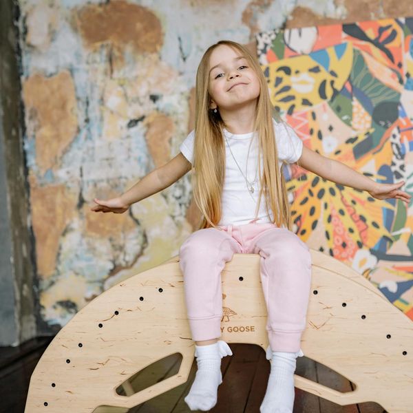 Happy child in a playful yoga pose on a colorful mat.