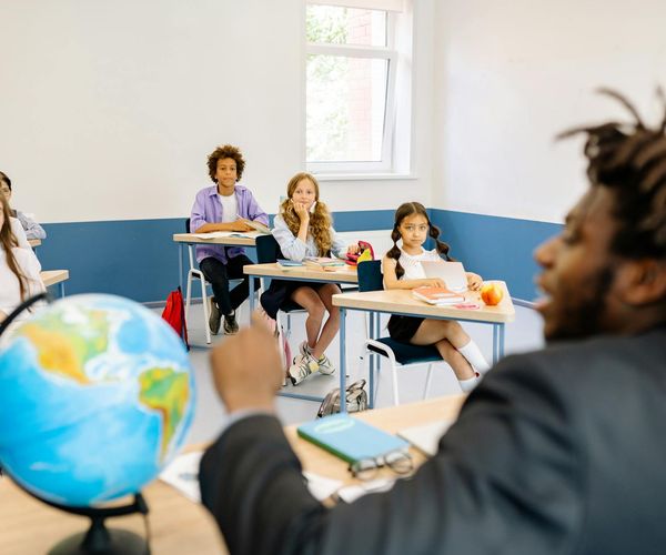 Instructor sitting with a group of children in a circle, telling a story.
